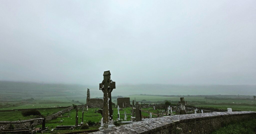 Celtic cross in a foggy churchyard, Ireland, 2025