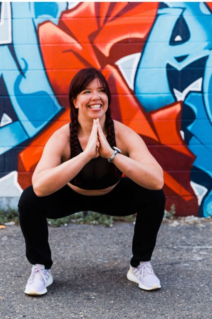 Squat pose at the colorful mural, Vibe photoshoot, 2021